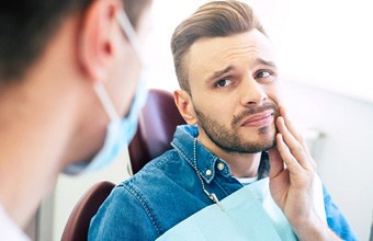 Man with dental sensitivity looking at dentist during appointment
