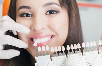 Smiling patient with tooth color chart