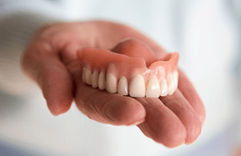 a person in Houston holding a set of dentures