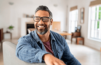 a man smiling after paying for the cost of dentures