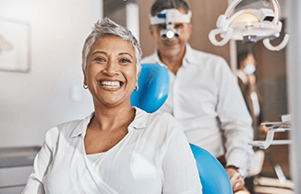 a patient smiling after receiving her new dentures