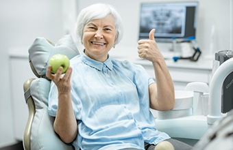 Older woman with dental implants in Houston smiling in dental chair