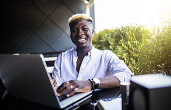 person working on their laptop and smiling