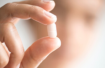 Hand holding a white table pill