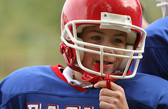 Young boy in football helmet with mouthguard