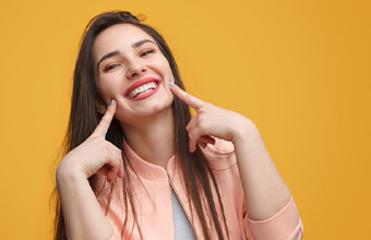 Smiling woman pointing to her mouth