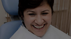 Smiling happy female patient in dental chair