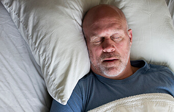 Man sleeping deeply in comfortable bed