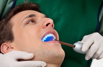 man having dental filling cured