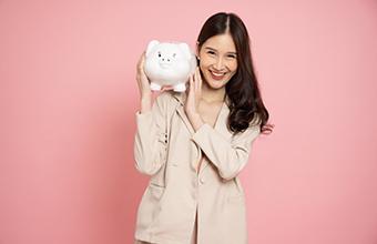 Smiling woman holding a piggy bank