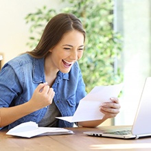 Woman celebrating at her desk after applying for CareCredit