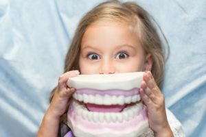 Young girl holding a dental mold at dentist in Houston. 