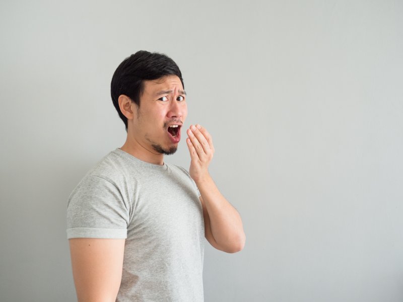 Man grimacing at bad breath