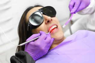Dentist carefully whitening a patient’s teeth