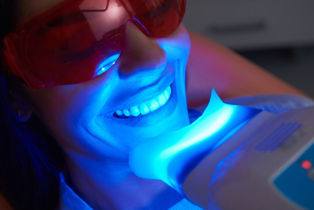 A woman getting professional teeth whitening treatment from her dentist