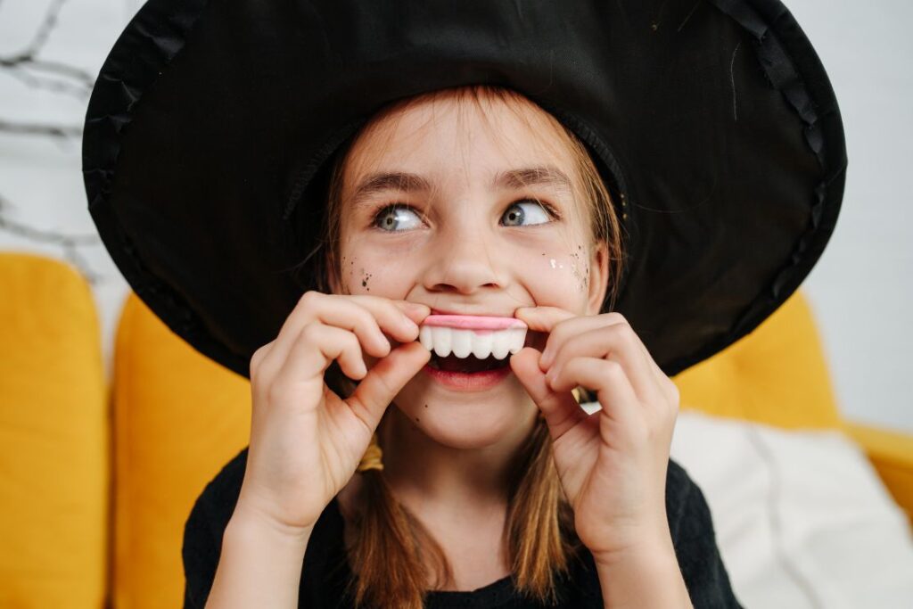 A little girl with fake vampire teeth